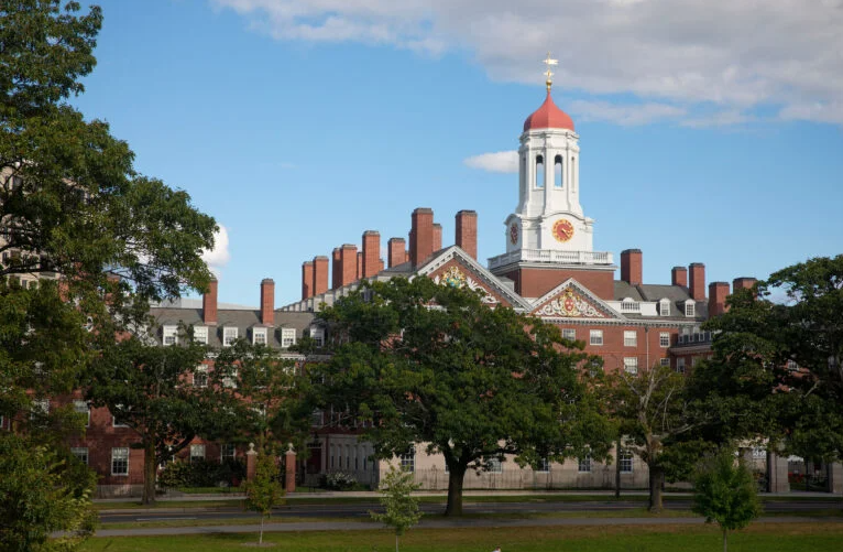 Dunster House tower behind lush, green trees.