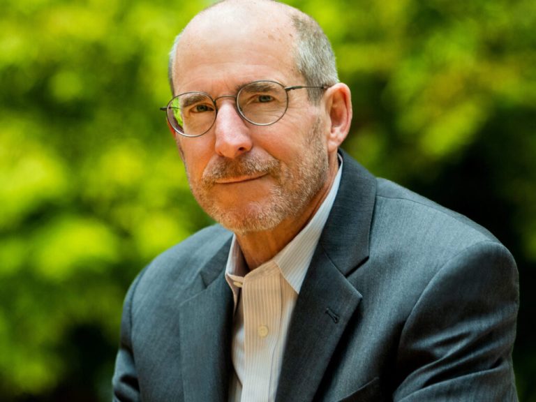 Jim Stock smiling with trees behind him