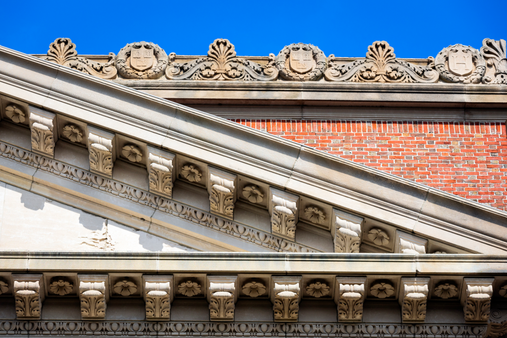 Detail of the Widener Library roof against a blue sky.