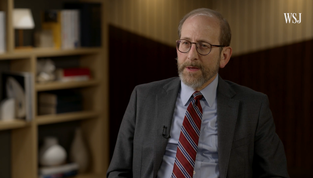 Alan Garber speaking to an interviewer in a suit and tie.