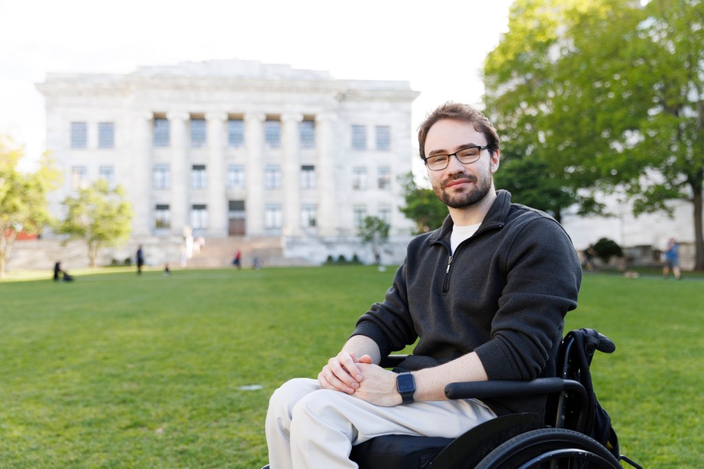Man in a wheelchair in front of Harvard Medical School.
