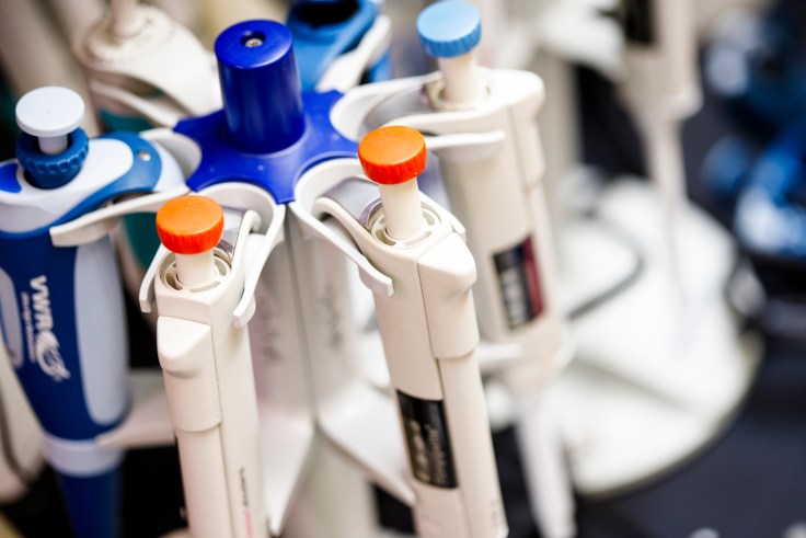 pipettes with colorful tops in a lab.