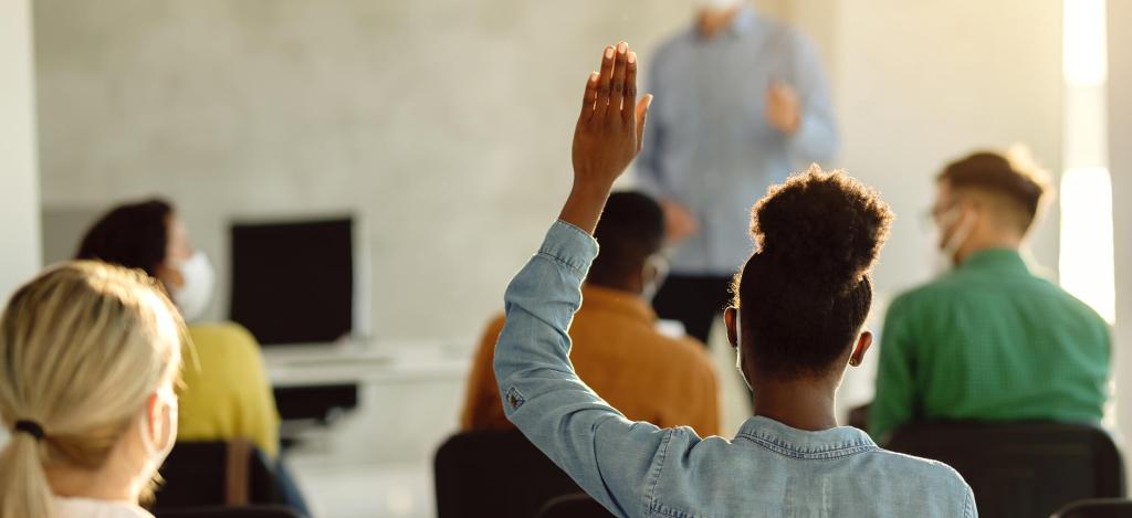 Back,View,Of,Black,Female,Student,Raising,Arm,To,Ask