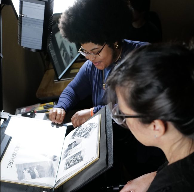 Two people using a high-quality Phase One camera to digitize an HBCU yearbook