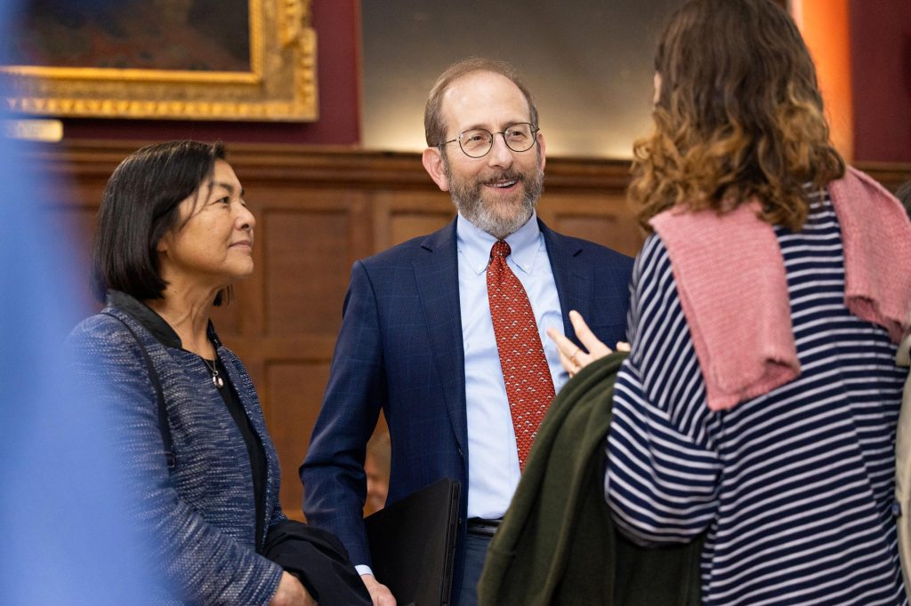 President Garber speaking with two women at Cambridge College.
