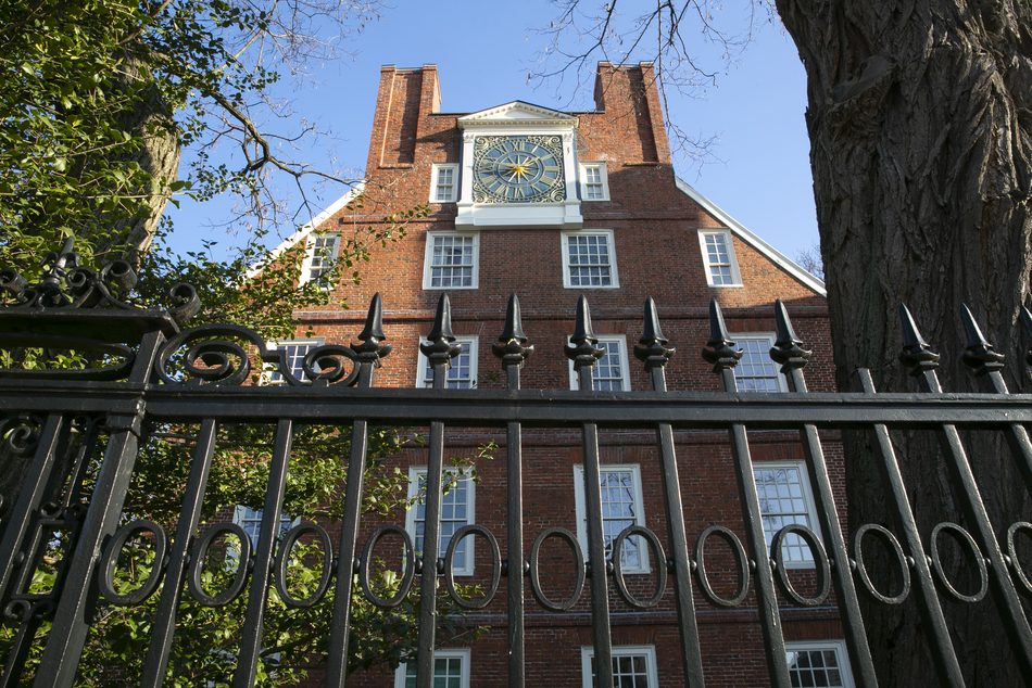 Looking up at Mass Hall and a clock that sits near the roofline.