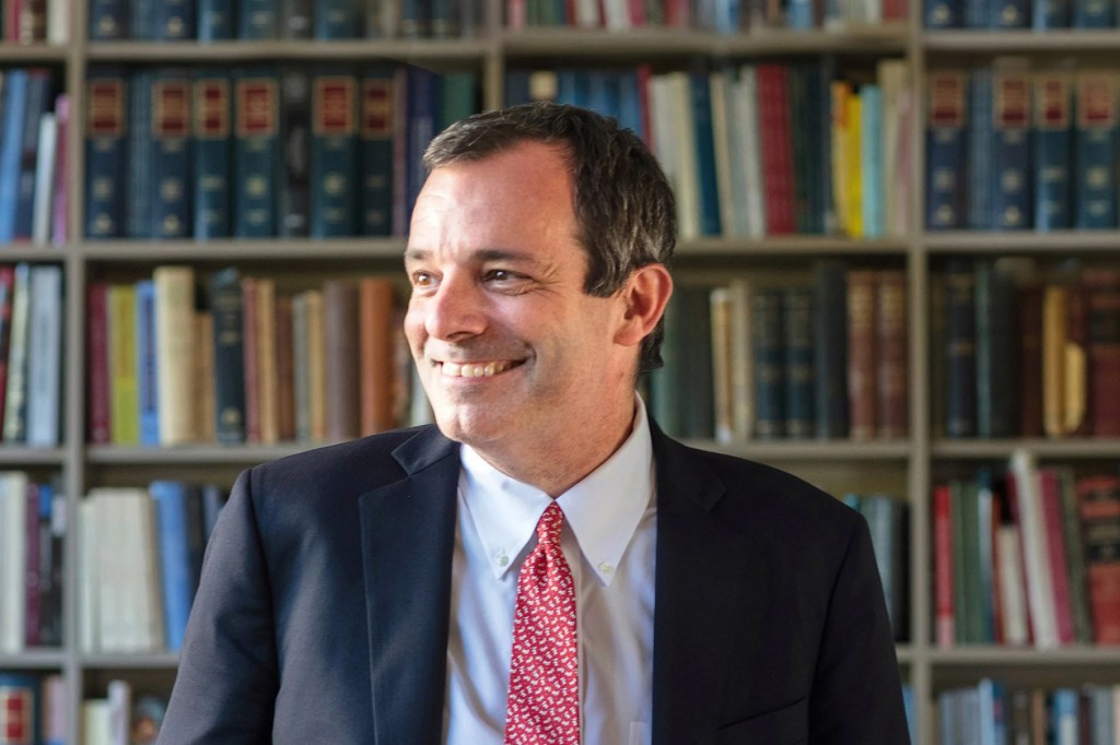 John F. Manning smiling in his office
