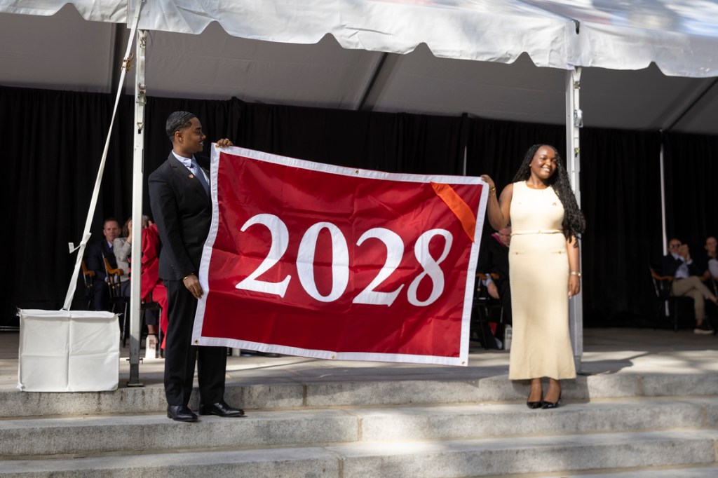 Two students hold a banner with "2028" on it.