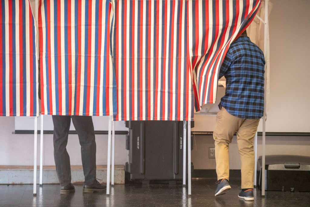 Two people in voting booths