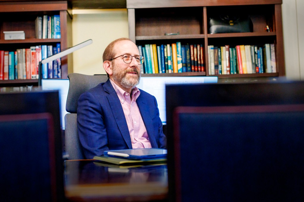 Alan Garber sitting at his desk in front of a bookshelf.