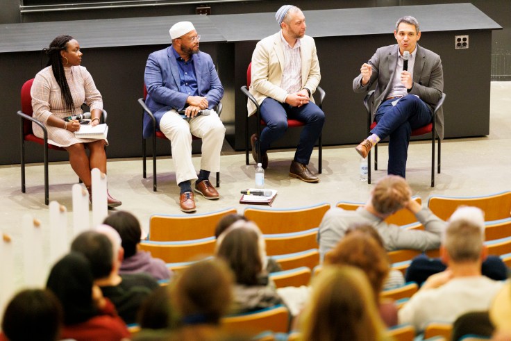 a panel of 4 people talking on stage