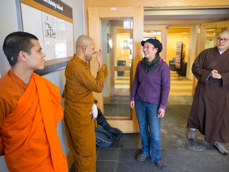 Several students dressed in various religious robes and clothing walking toward each other.