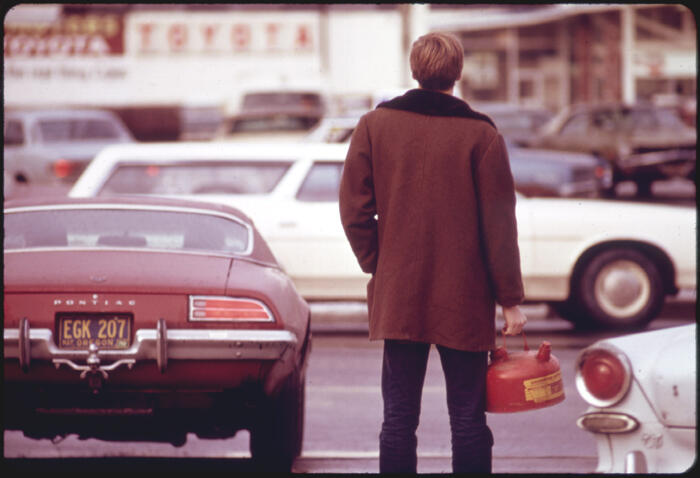 A man holding a metal gas can
