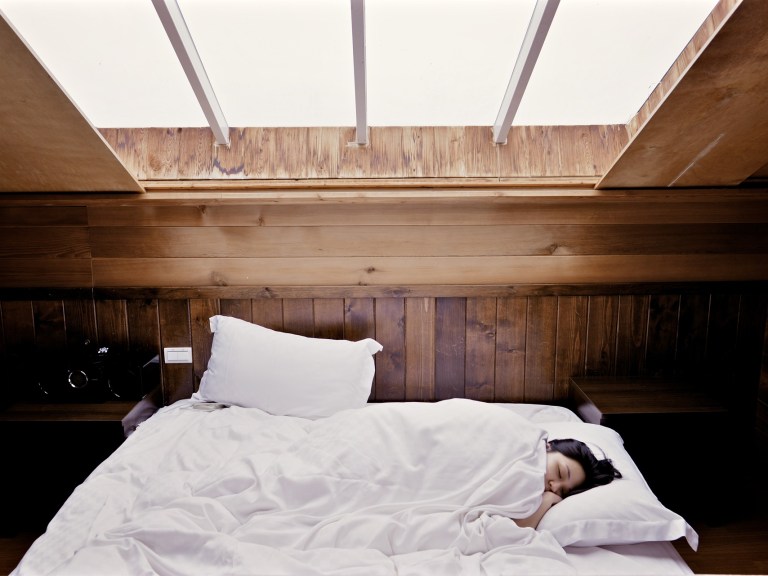 A person sleeping in a white bed