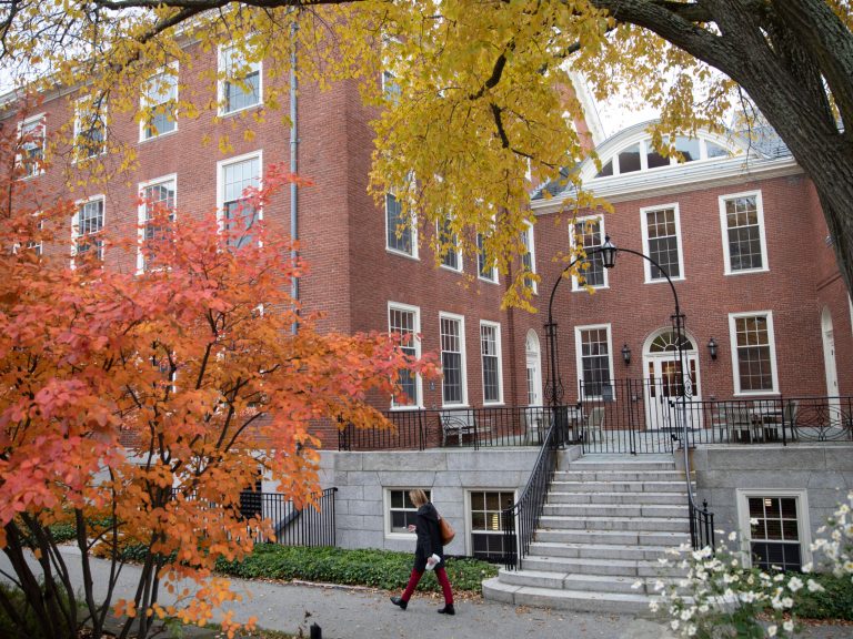 A person walking by a building on Radcliffe's campus