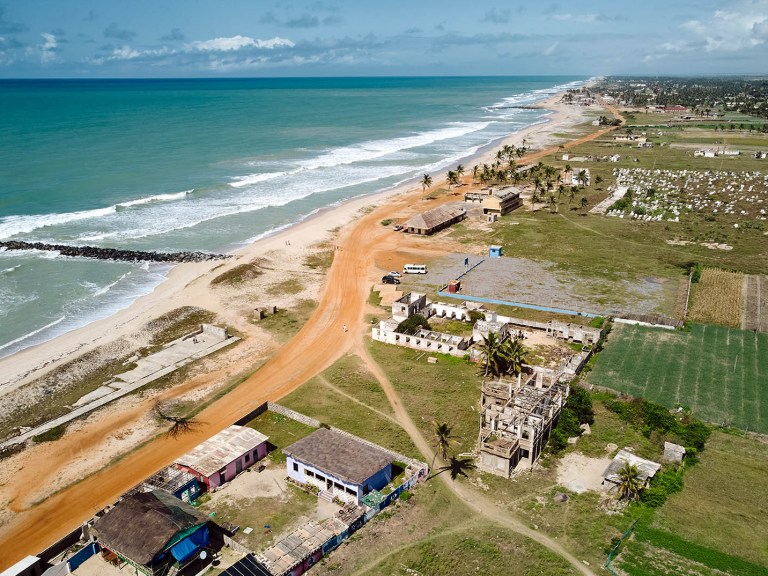 A beach area with buildings close to the water.