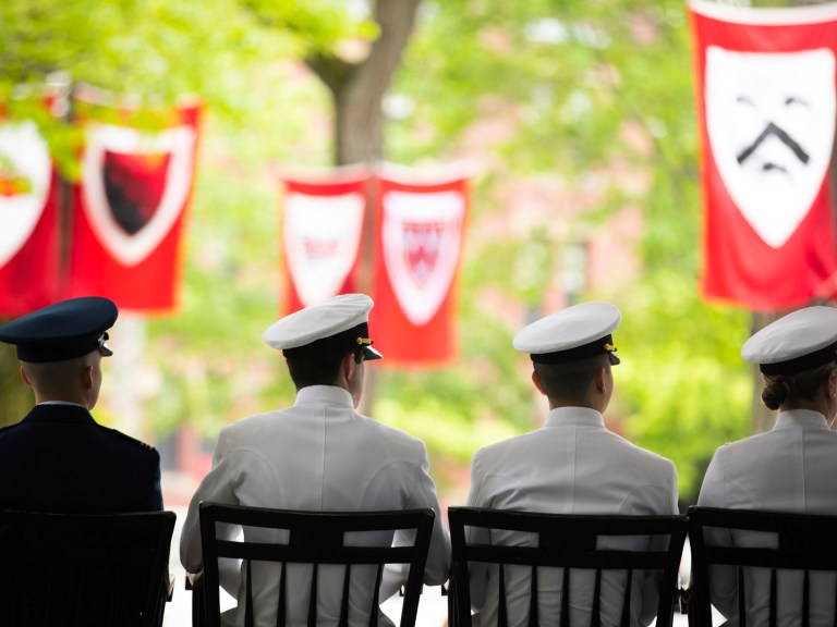 Members of ROTC sit on stage during a Commencement ceremony