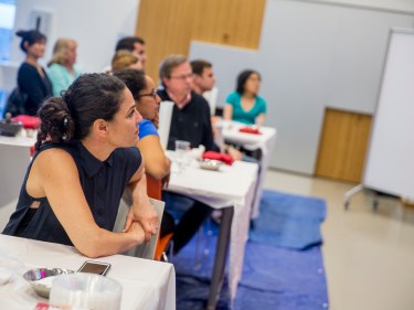 People sit at tables in a cooking class