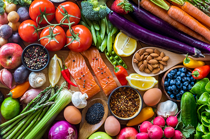 Healthy foods including nuts, seeds, fruits, vegetables, and fish.